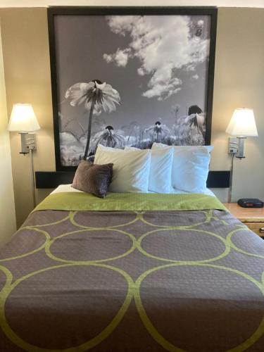 a bedroom with a bed with a large painting on the wall at Super 8 by Wyndham Chisago City in Chisago City