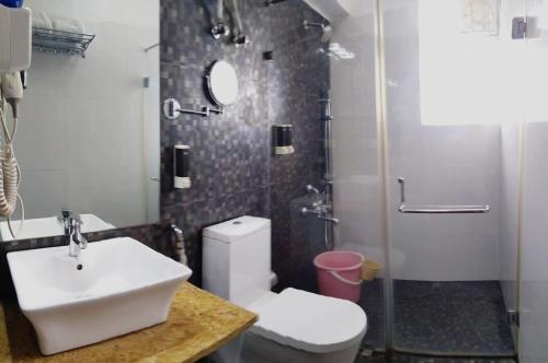 a bathroom with a sink and a toilet and a shower at Avi Fortune Suites - Near Bangalore International Airport in Bangalore