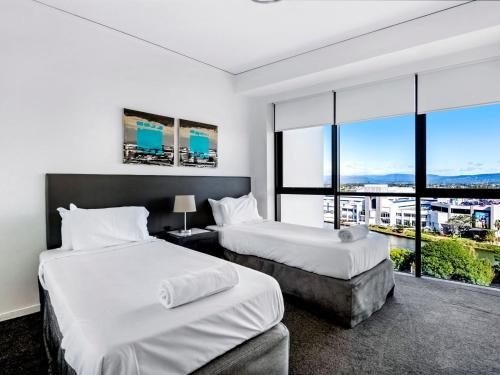 a hotel room with two beds and a large window at 3BR Apartment Hinterland Views - Sierra Grand CoastHM in Gold Coast