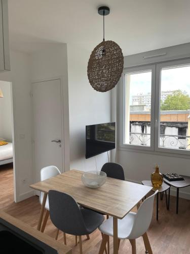 a dining room with a wooden table and chairs at Le Poulorio 10 - T2 - Proche Gare By Locly in Lorient