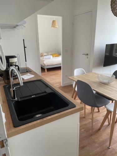 a kitchen with a sink and a table at Le Poulorio 10 - T2 - Proche Gare By Locly in Lorient