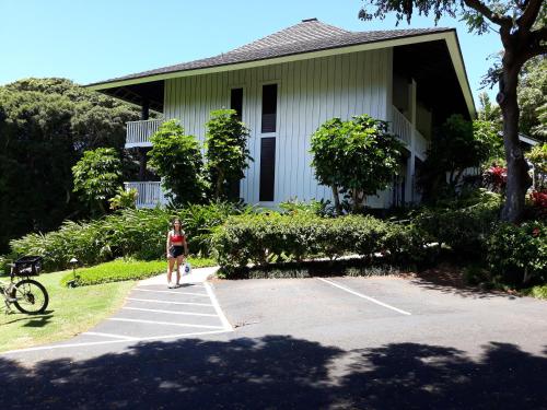 a woman walking in front of a house at Kiahuna Plantation 96, Poipu Beach, Club Membership, Part Ocean View, Kids Toys in Koloa