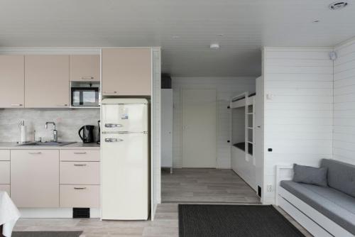 a kitchen with a refrigerator and a couch in a room at Saunalautta Sisu in Imatra
