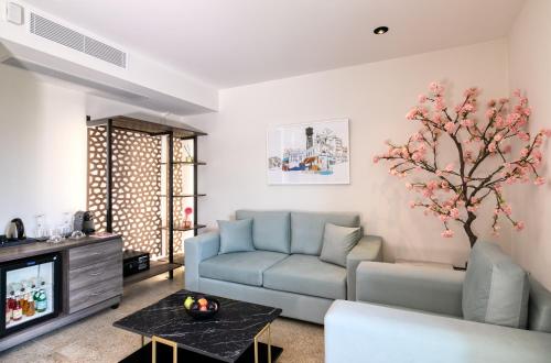 a living room filled with furniture and flowers at Athens Ivy Suites in Athens