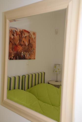 a mirror reflection of a bedroom with a green bed at Dio Guesthouses in Leonidion