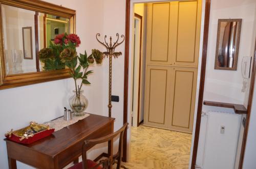 a room with a table with a vase of flowers and a mirror at Green Quercia Apartment in Como