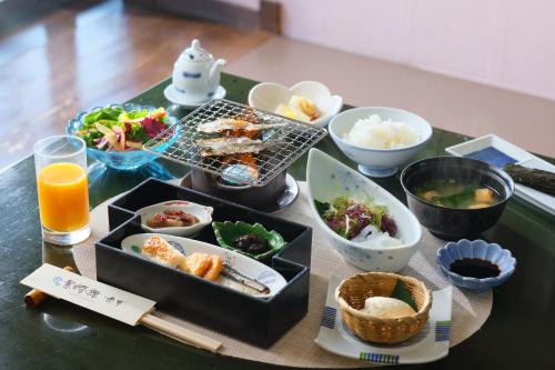a table topped with plates of food and bowls of food at Keishokan Sazanamitei in Fukuyama