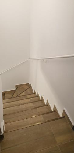 a staircase in a room with white walls and wooden floors at Cattleya's Loft in Veliko Tŭrnovo
