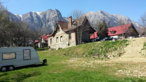 a caravan parked in a field in front of a house at Camping Aviator Busteni, Parcela campare Corturi in Buşteni