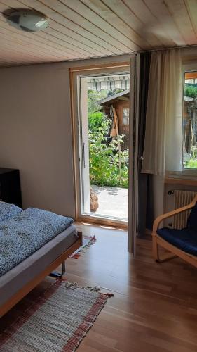 a bedroom with a bed and a door to a yard at Berner Oberland Am Thunersee in Därligen
