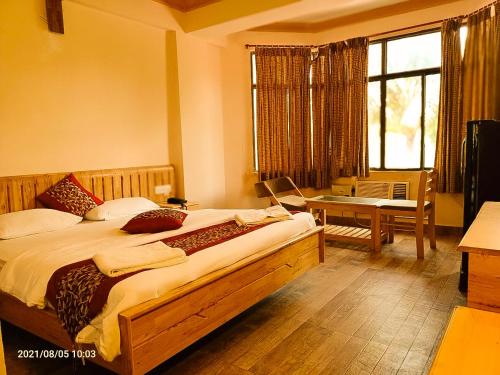 a bedroom with a large bed with a desk and a window at The Kingdom, Havelock in Havelock Island