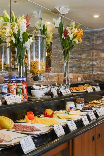 a buffet line with plates of food and flowers at Mirita Hotel ,10th Of Ramadan in Madinat Al Ashir min Ramadan