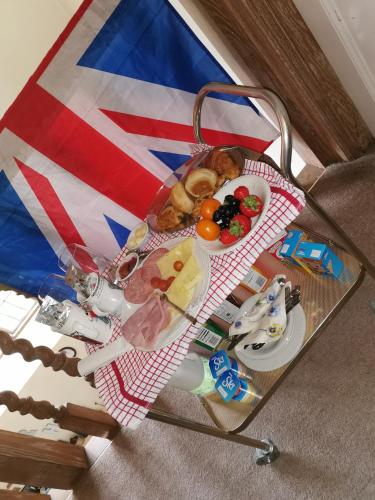 a table with a plate of food on it with a flag at PEACEFUL RETREAT HIDEAWAY SURREY in Esher