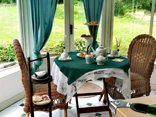 uma mesa com uma toalha de mesa verde e branca e cadeiras em PEACEFUL RETREAT HIDEAWAY SURREY em Esher