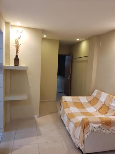 a bedroom with a bed with a striped comforter at Pousada Dragao Do Mar in Fortaleza