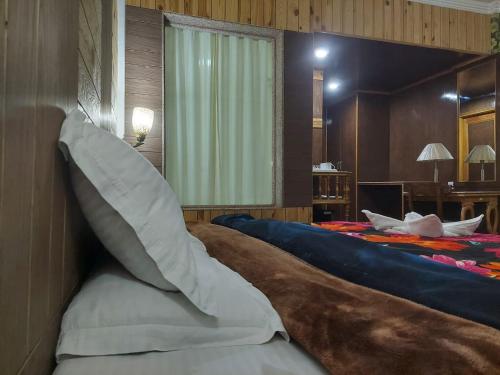 a bedroom with a large bed with a large pillow at Hotel Grand Habib in Srinagar