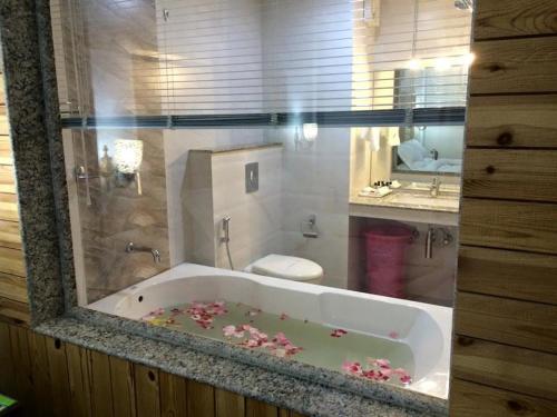 a bathroom with a tub with pink flowers in it at Hotel Grand Habib in Srinagar