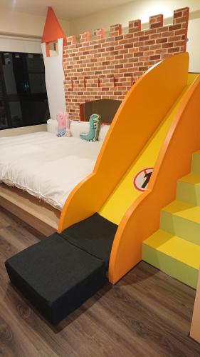 a childs bedroom with a bed and a brick wall at 胖蝸牛親子民宿 in Tainan