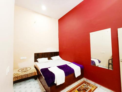 a red and white bedroom with a bed and a mirror at hari Darshan in Orchha