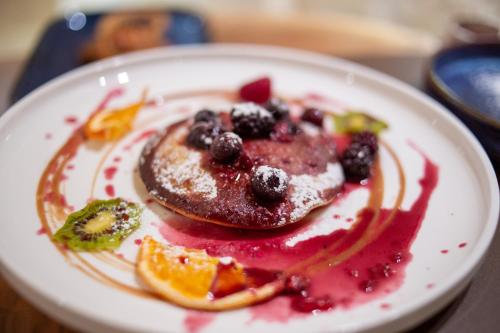 a plate of food with pancakes and fruit on a table at Pollicastro Boutique Hotel in Lecce