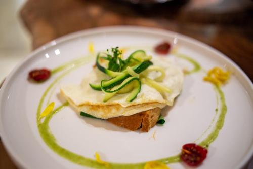 a white plate with a sandwich with vegetables on it at Pollicastro Boutique Hotel in Lecce