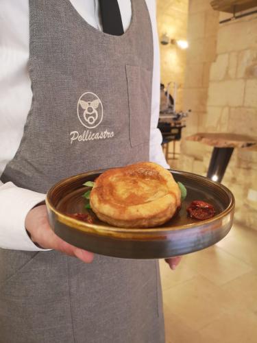 a person holding a plate with a sandwich on it at Pollicastro Boutique Hotel in Lecce