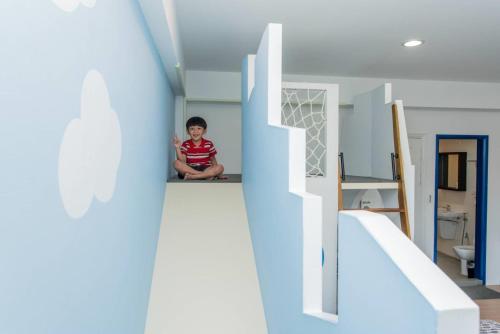 a little boy sitting on the floor of a house at 胖蝸牛親子民宿 in Tainan