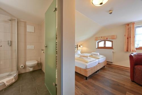 a bedroom with a bed and a shower and a toilet at Hotel Weinbauer in Schwangau