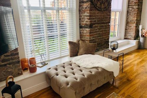 ein Wohnzimmer mit einer Couch vor einem Fenster in der Unterkunft Luxury, centrally located 2 bed modern apartment in Great Yarmouth