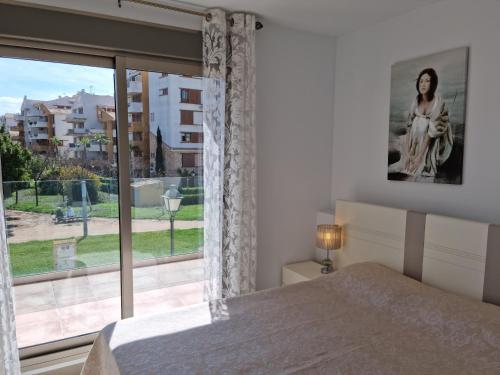 sypialnia z łóżkiem i dużym oknem w obiekcie SOLMAR w mieście Torrevieja