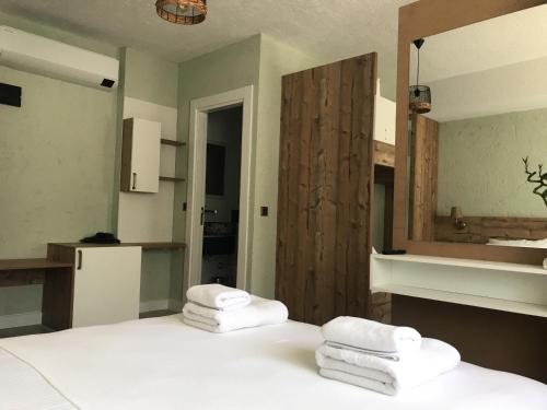 a bedroom with a white bed with towels on it at AKSOY TAŞ EV in Bodrum City
