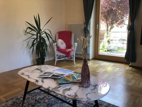 uma sala de estar com uma mesa e uma cadeira em MILLIEs hosting - Familienurlaub mit Hund in Kärnten em Sankt Paul im Lavanttal
