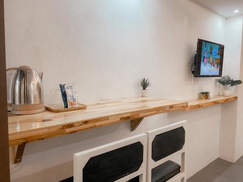 a wooden shelf on a wall with a television on it at Serene Daycation Antipolo in Cupang