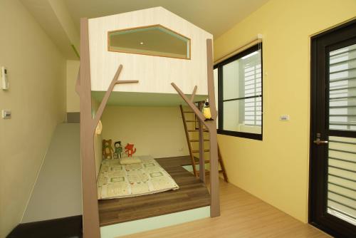 a room with a bunk bed and a ladder at 胖蝸牛親子民宿 in Tainan