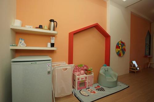 a toy kitchen with a refrigerator in a room at 胖蝸牛親子民宿 in Tainan