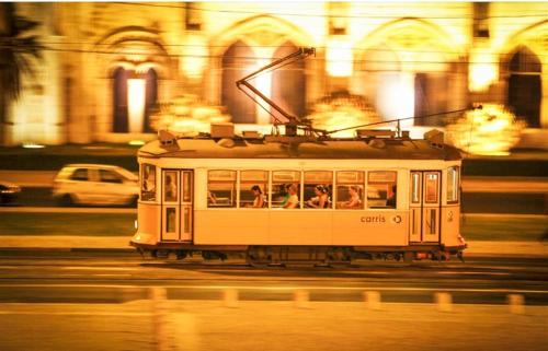 リスボンにあるTypical Lisbon centerの夜の街路を走る路面電車