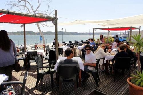 a group of people sitting at tables on a deck at New House Design, Typical Lisbon in Lisbon