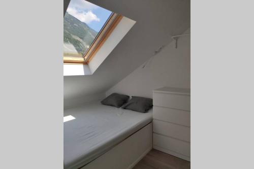 a small bed in a room with a window at Bovec Loft apartment in Bovec
