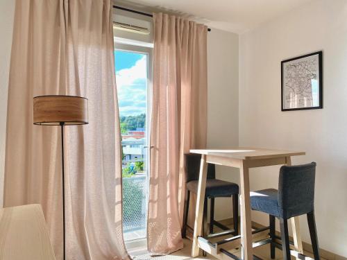 a room with a table and chairs and a window at Appartement en face Hopital Nord in Saint-Priest-en-Jarez