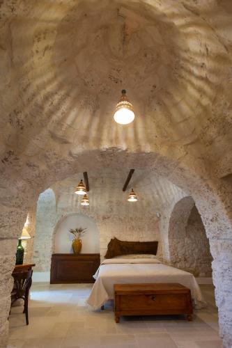 a bedroom with a bed in a stone wall at Terrazze Sulla Valle in Martina Franca