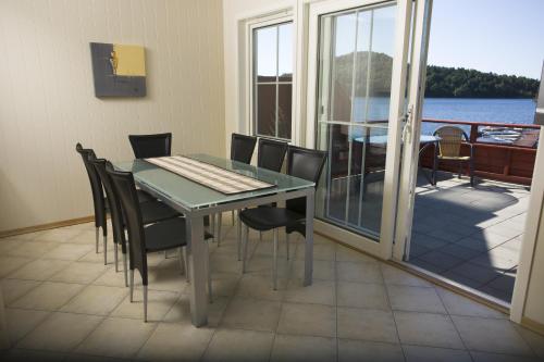 una sala da pranzo con tavolo e sedie e un balcone di Mones Feriesenter a Mandal