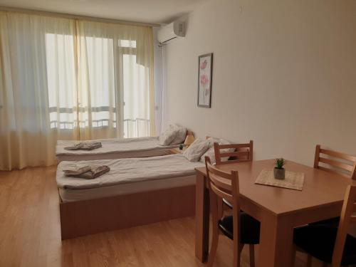Habitación con cama, mesa, mesa y sillas. en Apartman Maxim Lux en Razlog
