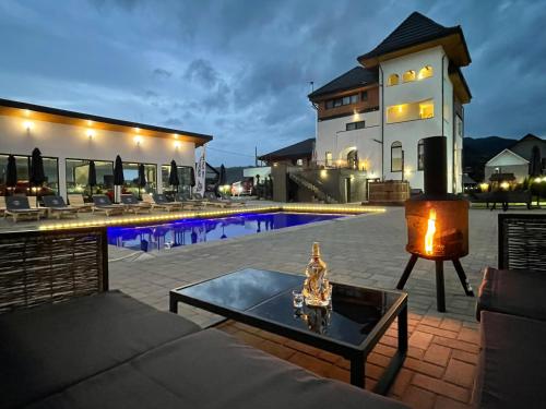 a patio with a table and a pool in front of a house at Pensiunea Maramures Guesthouse in Vişeu de Jos