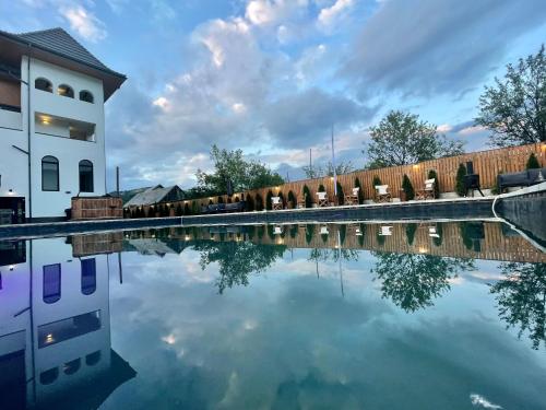 una piscina de agua frente a un edificio en Pensiunea Maramures Guesthouse en Vişeu de Jos