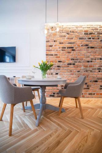 a dining room with a table and two chairs at Kopernika Apart in Toruń