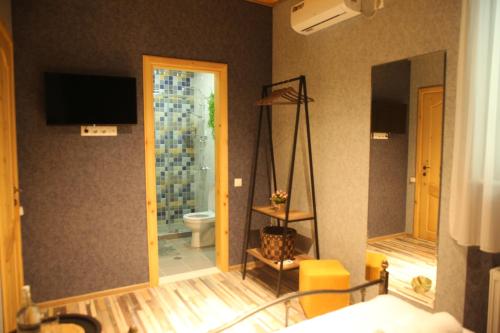 a room with a bathroom with a toilet and a television at Tbilisi Stories Hotel in Tbilisi City