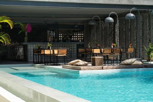 a pool with tables and chairs next to a bar at Casa Beach Hotel "Casa Del Mar" in Jambiani