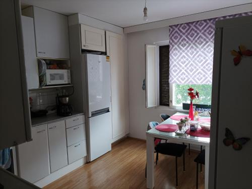 cocina con mesa y cocina pequeña con ventana en Hostel One Turku en Turku