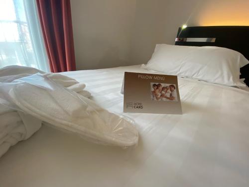 a book sitting on top of a white bed at Card International Hotel in Rimini