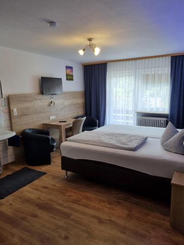 a bedroom with a bed and a desk and a television at Landhotel Engel in Limbach